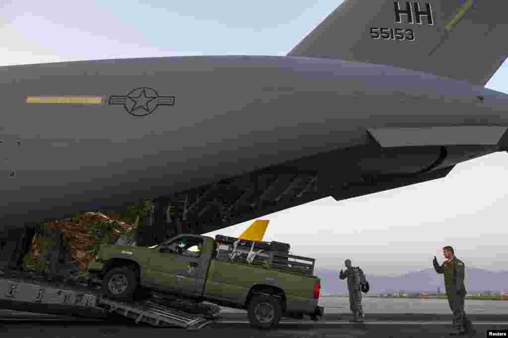 A vehicle is unloaded from a U.S. Air Force C-17A Globemaster III aircraft after it landed at Tribhuvan International in Kathmandu, May 5, 2015.