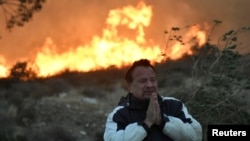 A man prays during an early-morning Creek Fire that broke out in the Kagel Canyon area in the San Fernando Valley north of Los Angeles, in Sylmar, California, Dec. 5, 2017. (REUTERS/Gene Blevins )