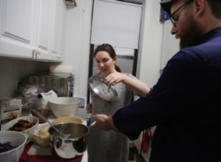 FILE - Shoshana Blum, 20, prepares Shabbat dinner with her father, Rabbi Yonah Blum, at their home in New York, Jan. 3, 2020.