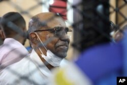 FILE - Sudan's ousted president Omar al-Bashir sits at the defendant's cage during his trial, at a courthouse in Khartoum, Sudan, Sept. 15, 2020.