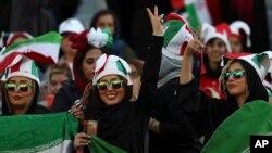 An Iranian woman flashes a victory sign during a soccer match between Iran and Cambodia in the 2022 World Cup qualifier at the Azadi (Freedom) Stadium in Tehran, Iran, Oct. 10, 2019. Iranian women were allowed into the stadium for the first time in years.