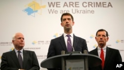 Сенатор Том Коттон (у центрі) виступає разом із сенатором Джоном Маккейном (ліворуч) і сенатором Джоном Баррассо (праворуч) на прес-конференції в Києві, Україна, 20 червня 2015 р.