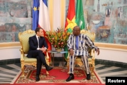 FILE - French President Emmanuel Macron attends a meeting with Burkina Faso's President Roch Marc Christian Kabore at the Presidential Palace in Ouagadougou, Burkina Faso, Nov. 28, 2017.