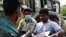 ঢাকার একটি রাস্তায় রিকশায় মাস্ক ছাড়া এক ব্যক্তির সঙ্গে একজন পুলিশ সদস্য কথা বলছেন। ১৩ জানুয়ারি ২০২২। (ছবি-এএফপি/মুনির উজ জামান)
