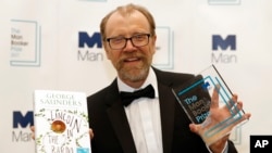 Author George Saunders of the United States holds his book "Lincoln in the Bardo" and his award as winner of the 2017 Man Booker Prize, in London, Oct. 17, 2017.
