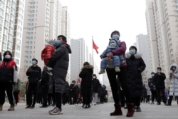 People practice social distancing as they line up for a second round of citywide coronavirus testing at a residential compound following new COVID-19 cases in Shijiazhuang, Hebei province, on Jan. 12, 2021.