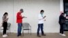 FILE - People who lost their jobs wait in line to file for unemployment at a Workforce Center in Fayetteville, Arkansas, April 6, 2020.