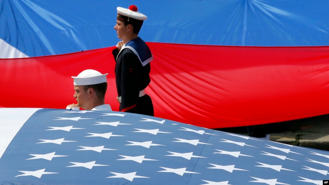 Tentara Prancis dan AS memajang bendera nasional mereka di akhir parade militer Hari Bastille di Champs Elysees di Paris, Prancis, Jumat, 14 Juli 2017. (Foto: AP/Michel Euler)