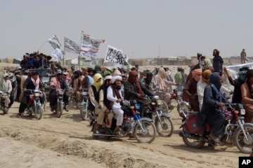 Hình minh họa - Máy bay trực thăng của Hoa Kỳ rời đi, trong khi chiến binh Taliban ngồi trên chiếc xe tăng bị bỏ hoang, bao quanh bởi những bông hoa anh túc đỏ.