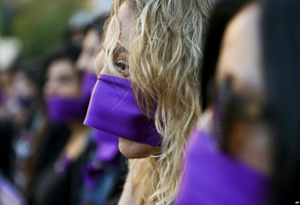 Women wear purple ribbons on their faces during the &quot;Todas en Silencio&quot; demonstration to mark the U.N.-designated International Women&#39;s Day, in front of La Moneda presidential palace in Santiago, Chile, March 8, 2017.