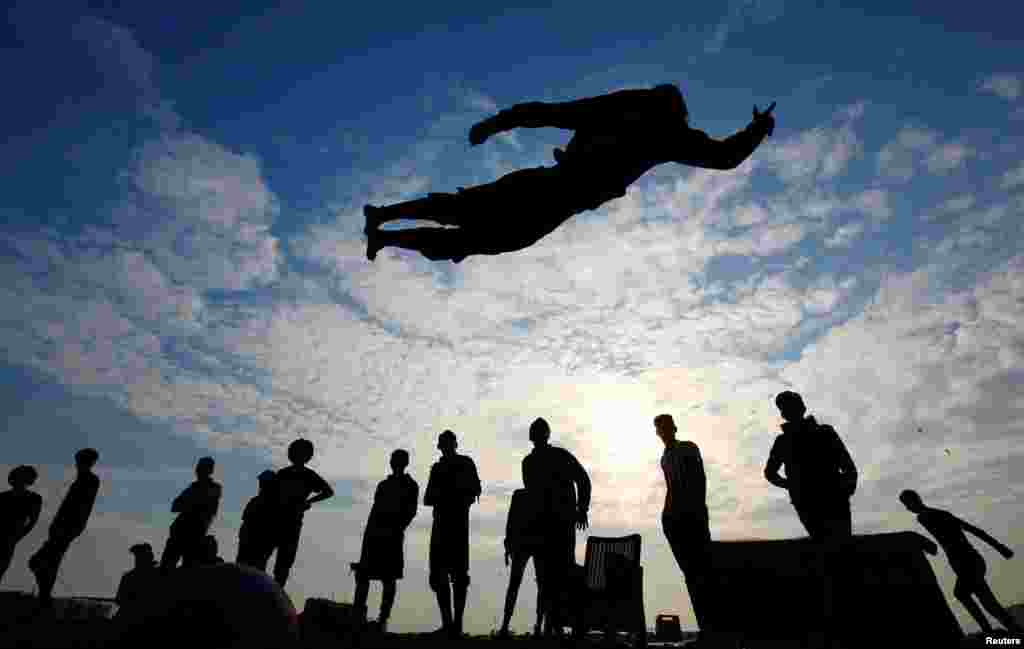 Iraqi demonstrators perform somersaults as they practice parkour during ongoing anti-government protests, near the Tigris River in Baghdad.