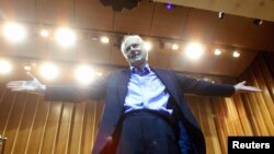 FILE - Legendary producer of "The Beatles," Sir George Martin, gestures after conducting the Cuban National Symphony Orchestra, Nov. 1, 2002.