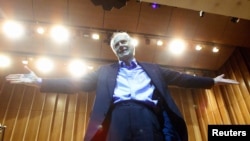 FILE - Legendary producer of "The Beatles," Sir George Martin, gestures after conducting the Cuban National Symphony Orchestra, Nov. 1, 2002.