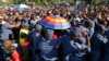South African police try to block mourners at a checkpoint while they attempt to walk to the Union building to see the body of former South African President Nelson Mandela, in Pretoria, Dec. 13, 2013. 