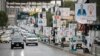 Traffic rolls past electoral campaign posters of candidates ahead of the Oct. 20 parliamentary election in the northern Iraqi city of Suleimaniyah on Oct. 19, 2024. 