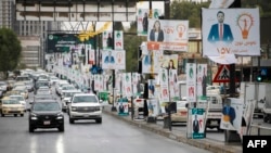 Traffic rolls past electoral campaign posters of candidates ahead of the Oct. 20 parliamentary election in the northern Iraqi city of Suleimaniyah on Oct. 19, 2024. 