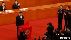 Chinese President Xi Jinping pauses after casting his ballot during a vote on a constitutional amendment lifting presidential term limits, at the third plenary session of the National People's Congress (NPC) at the Great Hall of the People in Beijing, Mar