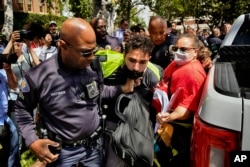 FILE— A University of Southern California protester is detained by USC Department of Public Safety officers during a pro-Palestinian occupation at the campus' Alumni Park on April 24, 2024, in Los Angeles.