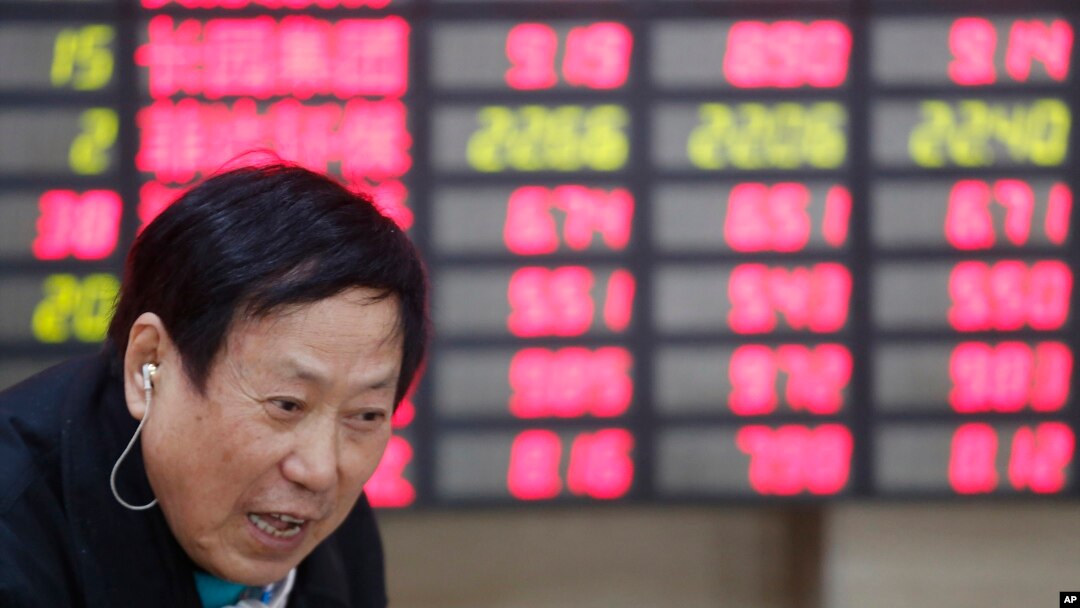An investor talks in front of the stock price monitor at a private securities company in Shanghai, China, Nov. 25, 2013. (AP)