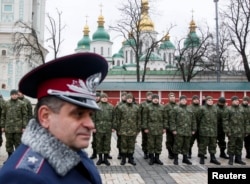 FILE - Members of the newly created Ukrainian interior ministry battalion "Saint Maria" take part in a ceremony before heading to military training, in front of St. Sophia Cathedral, in Kyiv, Feb. 3, 2015.