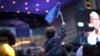 A young boy waves an EU flag as he watches a giant screen television outside the European Parliament in Brussels, Belgium, May 26, 2019.