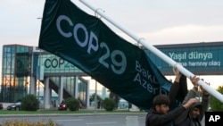 People set  a banner extracurricular  the venue for the COP29 U.N. Climate Summit, Nov. 18, 2024, successful  Baku, Azerbaijan.