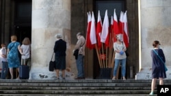 People keeping social distancing wait in line to vote in the presidential election in Warsaw, Poland, June 28, 2020.