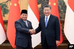 Presiden China Xi Jinping (kanan) berjabat tangan dengan Presiden terpilih Prabowo Subianto di Balai Agung Rakyat di Beijing pada Senin, 1 April 2024. (Yao Dawei/Xinhua via AP)