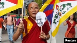 Seorang biarawan Budha dengan membawa bendera Tibet melakukan protes kebijakan China di Barcelona, Spanyol (foto: dok). Seorang biarawan di Tibet melakukan aksi protes dengan membakar diri, Senin (11/11). 