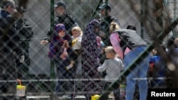 Para petugas kepolisian menjaga para perempuan dan anak-anak dari kombatan Kosovo yang kembali dari Suriah, di pusat tahanan orang asing di Pristina, Kosovo, 20 April 2019. (Foto: Reuters)