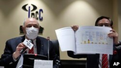 Ketua Dewan Pengaduan Polisi Independen (IPCC), Anthony Neoh (kiri) dan Wakil Ketua IPCC Hon Tony Tse Wai-chuen, menunjukkan laporan mereka tentang penanganan polisi terhadap protes demokrasi tahun lalu dalam konferensi pers di Hong Kong, 15 Mei 2020.