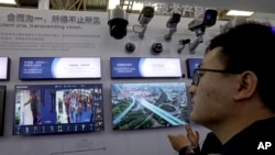 Seorang pria mengamati presentasi teknologi Hikvision, produsen peralatan pengawasan milik negara di pameran Keamanan China 2018 di Beijing, 23 Oktober 2018.(Foto: dok).