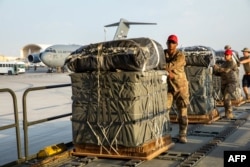 FILE — In this image obtained from the US Central Command, military personnel load humanitarian aid into US Air Force C-130 planes at an undisclosed location on March 5, 2024, in a joint US-Jordan operation.