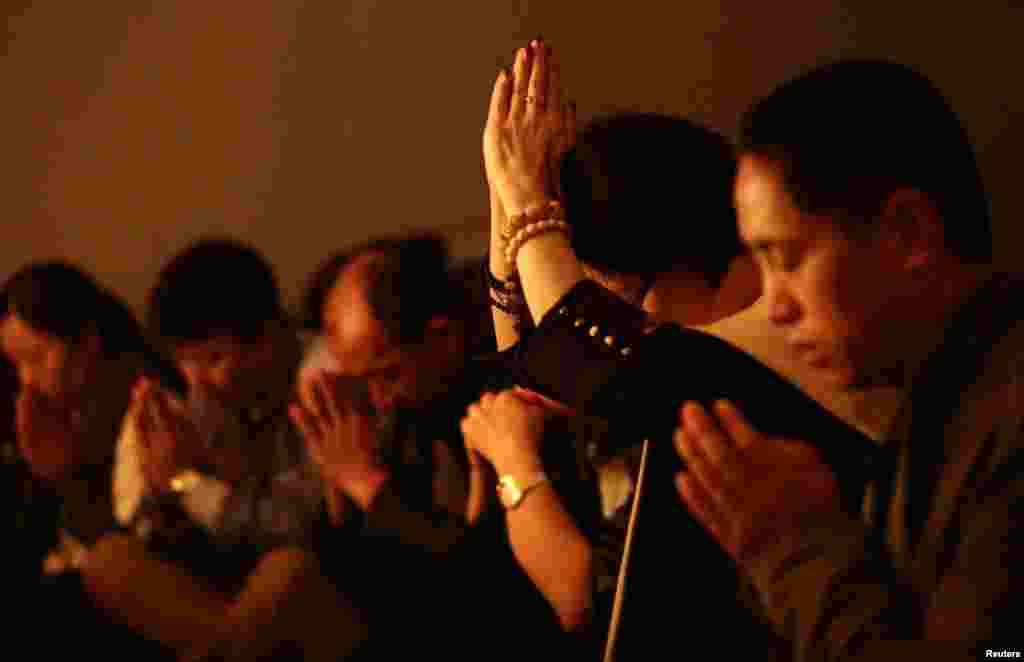 Relatives of passengers on flight MH370 pray at a praying room at Lido Hotel in Beijing, March 24, 2014.