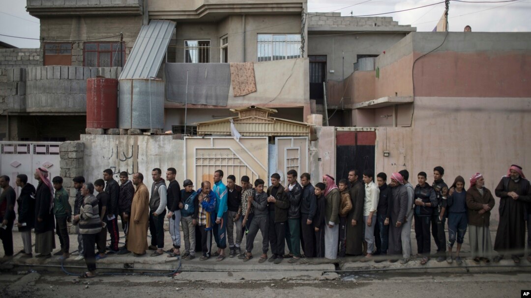 Warga Irak yang mengungsi dari Mosul barat antri untuk menerima pembagian makanan, Selasa (14/3).