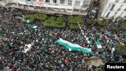 Demonstrators carry Algerian national flags during a protest calling on President Abdelaziz Bouteflika to quit, in Algiers, Algeria, March 22, 2019.