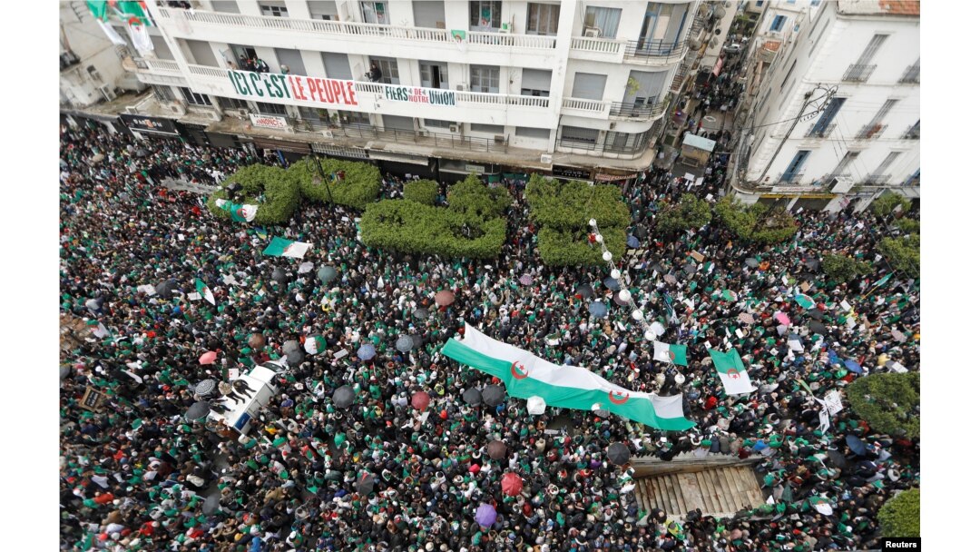 Demonstrators carry Algerian national flags during a protest calling on President Abdelaziz Bouteflika to quit, in Algiers, Algeria, March 22, 2019.