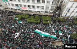Demonstrators carry Algerian national flags during a protest calling on President Abdelaziz Bouteflika to quit, in Algiers, Algeria, March 22, 2019.