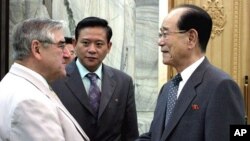 Kim Yong-nam (R), president of the Presidium of the Supreme People's Assembly of N. Korea, shakes hands with Jean-Claude Frecon, who is leading the delegation of the French group, at the Mansudae Assembly Hall in Pyongyang June 3, 2011, in this picture re