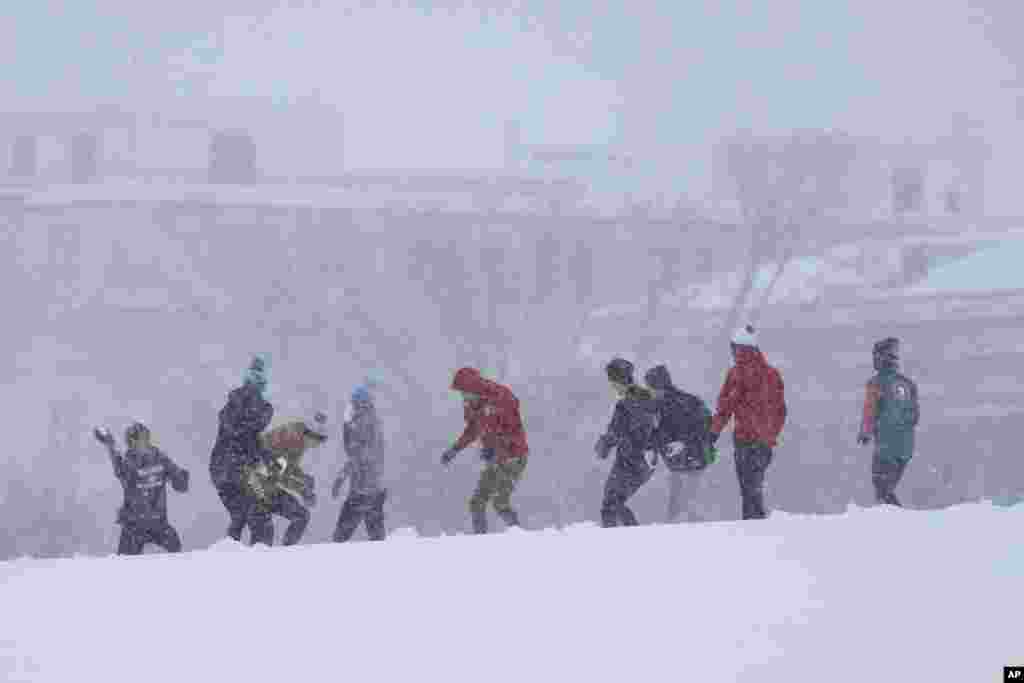 Personas participan en una pelea de bolas de nieve durante una tormenta de nieve invernal en Washington.