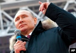 FILE - Russian President Vladimir Putin speaks during a massive rally in his support as a presidential candidate at the Luzhniki stadium in Moscow, Russia, March 3, 2018.
