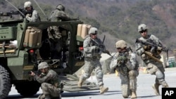 FILE - U.S. Army soldiers from the 25th Infantry Division's 2nd Stryker Brigade Combat Team and South Korean soldiers take part in an annual joint military exercise at the Rodriquez Multi-Purpose Range Complex in Pocheon, north of Seoul, South Korea, March 25, 2015.