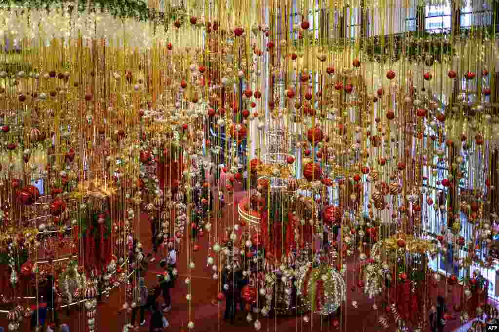 People walk at a shopping mall filled with Christmas decorations in Kuala Lumpur, Malaysia.