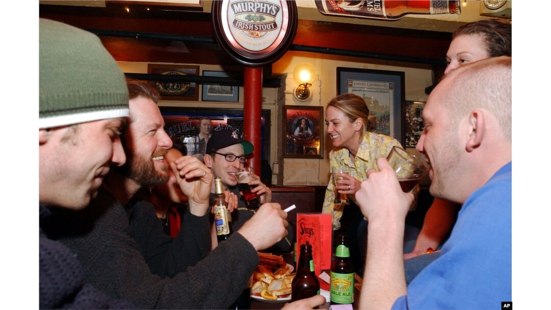 Para mahasiswa menikmati bir di sebuah pub di Cambridge, Massachusetts, 24 Maret 2002. (Foto: AP)