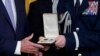 Vojni pomoćnik dodaje Presidental Citizens Medal, drugo najviše civilno odlikovanje u zemlji, predsjedniku Joeu Bidenu tokom ceremonije u istočnoj sobi Bijele kuće u Washingtonu, 6. januara 2023.