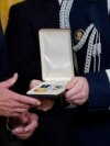 Vojni pomoćnik dodaje Presidental Citizens Medal, drugo najviše civilno odlikovanje u zemlji, predsjedniku Joeu Bidenu tokom ceremonije u istočnoj sobi Bijele kuće u Washingtonu, 6. januara 2023.