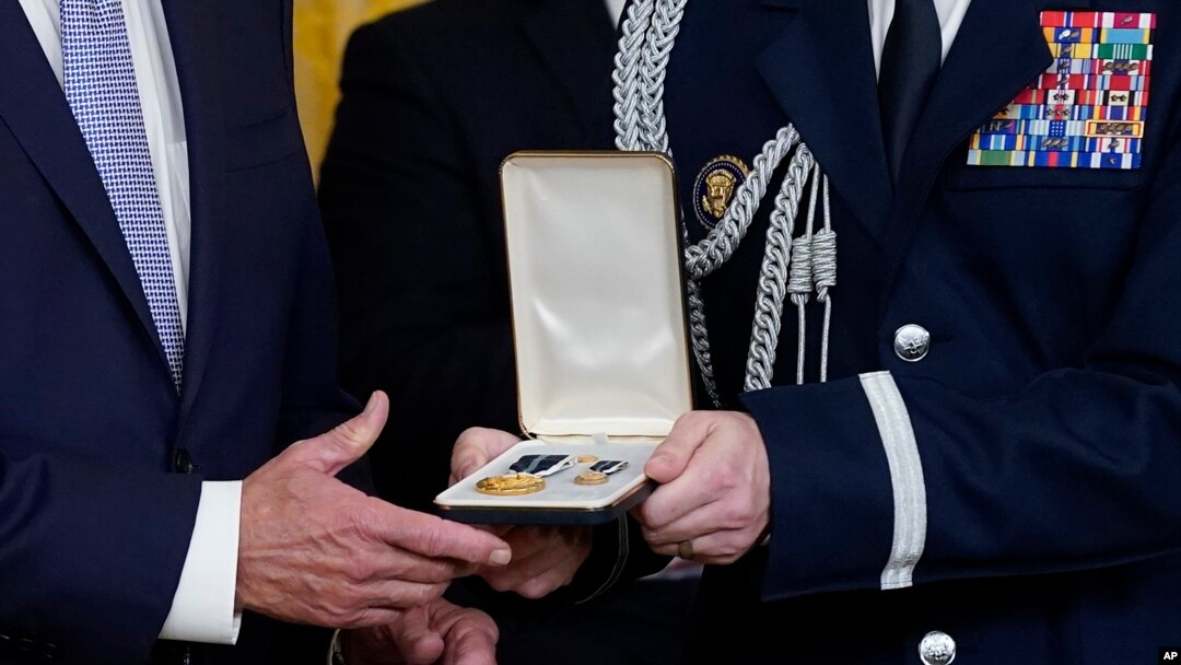 Vojni pomoćnik dodaje Presidental Citizens Medal, drugo najviše civilno odlikovanje u zemlji, predsjedniku Joeu Bidenu tokom ceremonije u istočnoj sobi Bijele kuće u Washingtonu, 6. januara 2023.