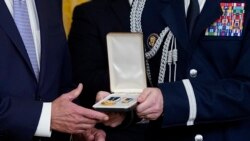 Vojni pomoćnik dodaje Presidental Citizens Medal, drugo najviše civilno odlikovanje u zemlji, predsjedniku Joeu Bidenu tokom ceremonije u istočnoj sobi Bijele kuće u Washingtonu, 6. januara 2023.