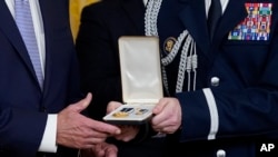 Vojni pomoćnik dodaje Presidental Citizens Medal, drugo najviše civilno odlikovanje u zemlji, predsjedniku Joeu Bidenu tokom ceremonije u istočnoj sobi Bijele kuće u Washingtonu, 6. januara 2023.