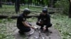 Ukrainian police officers examine fragments of a missile in the central park of Kharkiv on May 19, 2024, amid the Russian invasion of Ukraine.